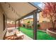 Backyard retreat features a covered patio with outdoor furniture, artificial grass, and a charming garden at 10623 Kearney Mountain Ave, Las Vegas, NV 89166