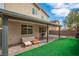 Inviting backyard features a covered patio, paver flooring, artificial grass, and outdoor furniture at 10623 Kearney Mountain Ave, Las Vegas, NV 89166