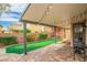 Backyard features a covered patio with string lights, artificial grass, and a paver patio at 10623 Kearney Mountain Ave, Las Vegas, NV 89166