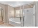 Relaxing bathroom showcases a soaking tub with white tile surround and a separate shower with glass door at 10623 Kearney Mountain Ave, Las Vegas, NV 89166