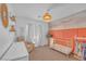 Charming Bedroom with coral accent wall, a woven pendant light, and a cute crib with hanging clothes at 10623 Kearney Mountain Ave, Las Vegas, NV 89166