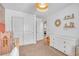 Bright bedroom features neutral carpet, white walls, woven light fixture, white dresser, and closet at 10623 Kearney Mountain Ave, Las Vegas, NV 89166