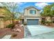 Two-story home featuring a gray two-car garage, tidy landscaping, and a charming stone-accented entrance at 10623 Kearney Mountain Ave, Las Vegas, NV 89166