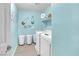 Bright laundry room with blue walls, modern washer and dryer, and decorative laundry-themed wall art at 10623 Kearney Mountain Ave, Las Vegas, NV 89166