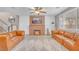 Bright living room with leather sofas, a brick fireplace, and a ceiling fan enhancing comfort at 10623 Kearney Mountain Ave, Las Vegas, NV 89166