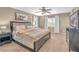 Well-lit main bedroom featuring a dark-wood bed, ceiling fan, and a matching dark-wood nightstand and dresser at 10623 Kearney Mountain Ave, Las Vegas, NV 89166