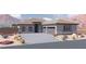 Charming single story home featuring a neutral color scheme, a two car garage, and desert landscaping at 1860 Old West Ave, Pahrump, NV 89048