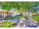 Well-manicured backyard featuring a putting green, mature trees, landscaping and a covered patio at 1897 Holdenville St, Henderson, NV 89052