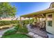 Lush backyard featuring a covered patio, manicured landscaping and a dining set at 1897 Holdenville St, Henderson, NV 89052