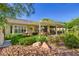 Landscaped backyard with a covered patio, water fountain, and lush greenery, creating a serene outdoor space at 1897 Holdenville St, Henderson, NV 89052