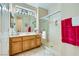 Bright bathroom featuring light wood vanity, large mirror and glass-enclosed shower with vibrant pink towels at 1897 Holdenville St, Henderson, NV 89052