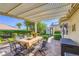 Inviting covered patio with an outdoor dining area, water feature, and well-maintained landscaping at 1897 Holdenville St, Henderson, NV 89052