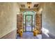 Charming courtyard entryway with stone columns, decorative iron gate, and potted floral arrangements at 1897 Holdenville St, Henderson, NV 89052