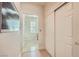 Neutral hallway leading to a bathroom, featuring tile floors and storage closet at 1897 Holdenville St, Henderson, NV 89052