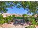 Inviting outdoor seating area with a round table and chairs, surrounded by lush landscaping and mature trees at 1897 Holdenville St, Henderson, NV 89052