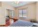 Bedroom with wood floor and mirrored closet doors and light from bright window at 2016 Biloxi Pass, Henderson, NV 89052