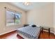 Cozy bedroom showcasing hardwood floors, ceiling fan, and sunlit window view at 2016 Biloxi Pass, Henderson, NV 89052