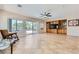Bright living room featuring tile flooring, a ceiling fan, backyard access, and built-in shelving at 2016 Biloxi Pass, Henderson, NV 89052