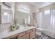 Cozy bathroom featuring a large mirror, vanity with sink, toilet, and bathtub with shower curtain at 2050 W Warm Springs Rd # 1923, Henderson, NV 89014