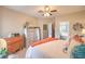 Well-lit bedroom showcasing neutral walls, ceiling fan, dresser storage, and ensuite bathroom access at 2050 W Warm Springs Rd # 1923, Henderson, NV 89014