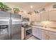 Updated kitchen with stainless steel refrigerator and microwave plus light-colored cabinets and countertops at 2050 W Warm Springs Rd # 1923, Henderson, NV 89014