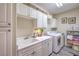 Well-organized laundry room featuring white cabinets, modern washer, dryer, and ample counter space at 2050 W Warm Springs Rd # 1923, Henderson, NV 89014