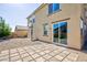 Home's backyard showing gravel landscaping, a stone-tiled patio and sliding glass doors at 210 Red Sandstone Ave, North Las Vegas, NV 89031
