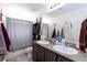 Bathroom features double sinks with granite countertops, a shower, and a toilet at 210 Red Sandstone Ave, North Las Vegas, NV 89031