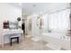 Bright bathroom featuring white cabinetry, shower, bathtub, and vanity with stool at 210 Red Sandstone Ave, North Las Vegas, NV 89031