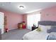 Cozy bedroom with pink walls features a comfortable bed with accent pillows and curtains for a peaceful retreat at 210 Red Sandstone Ave, North Las Vegas, NV 89031