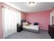 Cozy bedroom with pink walls features a comfortable bed with accent pillows and curtains for a peaceful retreat at 210 Red Sandstone Ave, North Las Vegas, NV 89031