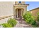 Inviting entryway featuring a covered porch with a seating area and decorative plants at 210 Red Sandstone Ave, North Las Vegas, NV 89031