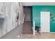 Carpeted staircase with white railing leads to the upper level, complemented by artistic wall decor and vibrant teal accent wall at 210 Red Sandstone Ave, North Las Vegas, NV 89031