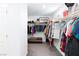 Organized walk-in closet with clothing racks, shoe storage, and a central bench for convenience at 210 Red Sandstone Ave, North Las Vegas, NV 89031