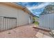 Side view of a gravel yard with a small storage shed and greenery alongside the house at 224 Catalini St, Las Vegas, NV 89107