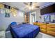 A neatly decorated bedroom with blue accents, dresser, ceiling fan, and ample natural light at 224 Catalini St, Las Vegas, NV 89107