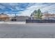 Street view of home with black fence, carport, desert landscaping, and horizontal siding at 224 Catalini St, Las Vegas, NV 89107