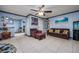 Living room with neutral tile, blue-gray accent walls, ceiling fan, and brown sofa and love seat at 224 Catalini St, Las Vegas, NV 89107