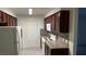 Efficient kitchen with white appliances, tile backsplash, and dark wooden cabinetry at 2606 S Durango Dr # 142, Las Vegas, NV 89117