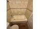 Compact bathroom featuring a tub with beige tile surround and dark wood-look flooring at 2655 Aracatuba Ave, Las Vegas, NV 89121