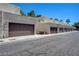 Row of townhomes with garages, tan stucco exteriors, and brown garage doors at 2655 Aracatuba Ave, Las Vegas, NV 89121