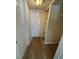 Hallway with hardwood flooring, white trim, and white doors, providing access to storage at 2655 Aracatuba Ave, Las Vegas, NV 89121