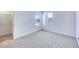 Bright bedroom features plush carpeting, neutral tones, and natural light from two windows at 2728 Tricase St, Henderson, NV 89044