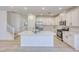 Bright white kitchen featuring a large island, stainless steel appliances, and sleek countertops at 2728 Tricase St, Henderson, NV 89044