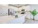 Bright white kitchen featuring a large island, stainless steel appliances, and sleek countertops at 2728 Tricase St, Henderson, NV 89044