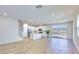 Bright open-concept living room and kitchen with light wood floors and sliding glass doors leading to balcony at 2728 Tricase St, Henderson, NV 89044