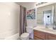Bright bathroom features a vanity with wood cabinets, white tiles and a shower/tub combination at 2738 Sandalwood Ave, Henderson, NV 89074
