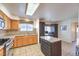 Open kitchen with dark cabinetry, a cooktop, tile backsplash and a view to the entry at 2738 Sandalwood Ave, Henderson, NV 89074