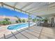 Covered patio with lounge seating overlooking a refreshing backyard pool and garden at 2738 Sandalwood Ave, Henderson, NV 89074