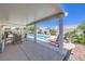 Backyard patio with dining set overlooks a sparkling pool and lush landscaping, ideal for summer gatherings at 2738 Sandalwood Ave, Henderson, NV 89074